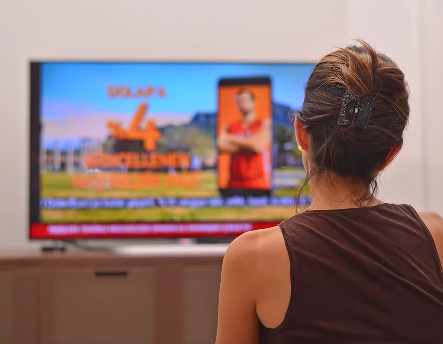Woman watching TV advertisement.